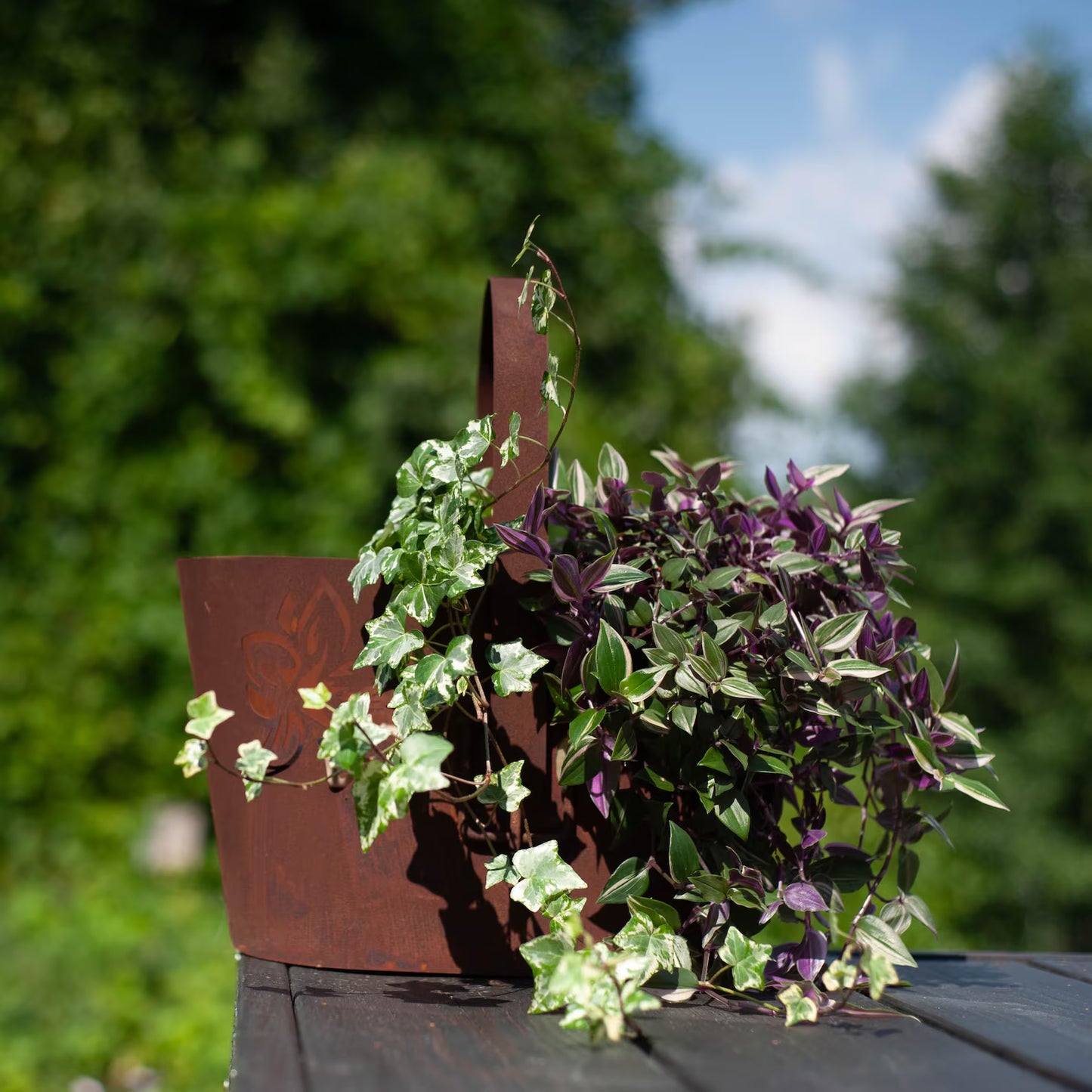 Rustic metal planter with handle, cut-out floral pattern, natural rusty finish
